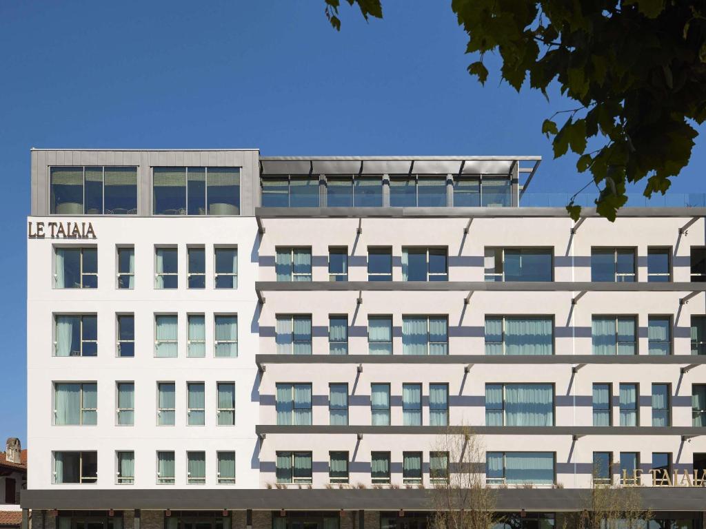 a white building with a lot of windows at Le Talaia Hôtel & Spa Biarritz - MGallery Collection in Biarritz