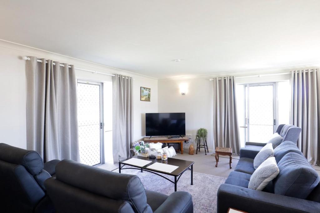 テンターフィールドにあるFamily Retreat in Central Tenterfieldの青いソファ2脚とテレビのあるリビングルーム