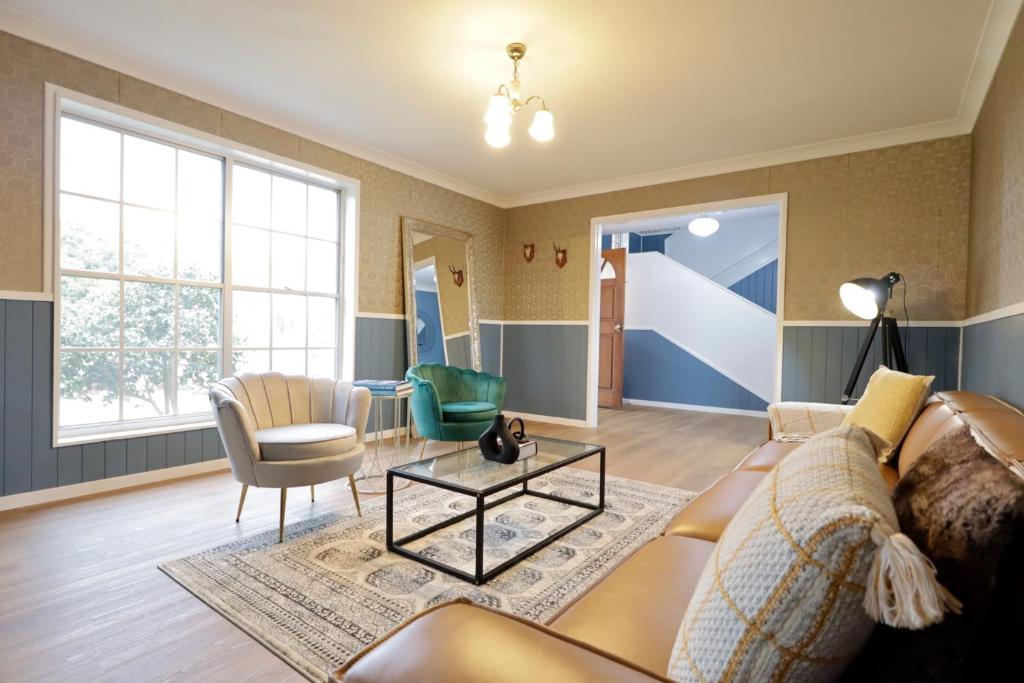 una sala de estar con un sofá y una mesa en Country 4-Bed Homestead with Games Room & Views, en Tenterfield