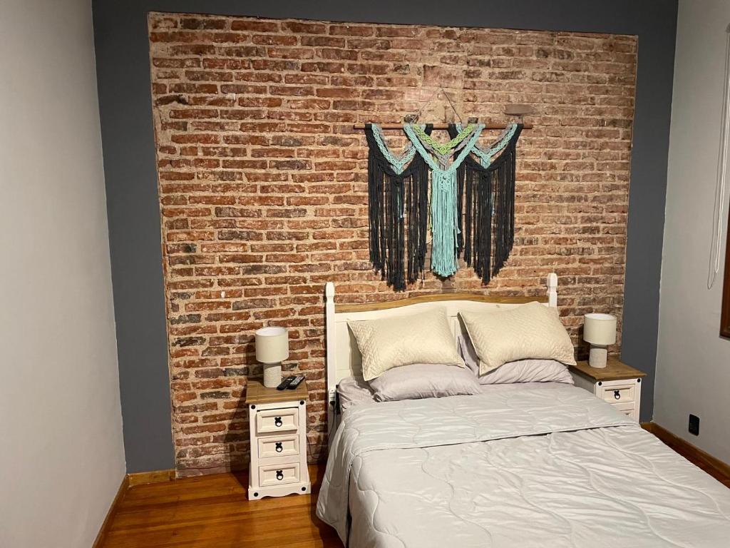 une chambre avec un mur de briques et un lit dans l'établissement Excepcional apartamento en Palacio Salvo, à Montevideo