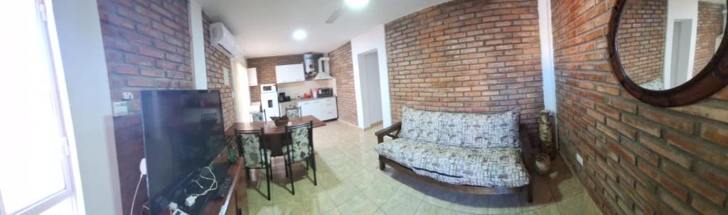 Zimmer mit Ziegelwand, Bank und Spiegel in der Unterkunft Nuevo Complejo Milena in San Juan