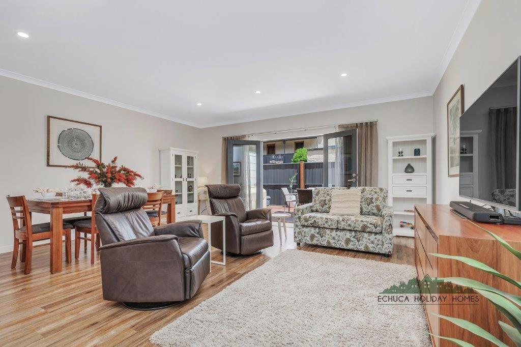 una sala de estar con una mesa y sillas en Campaspe Central - Your Central Echuca Escape!, en Echuca