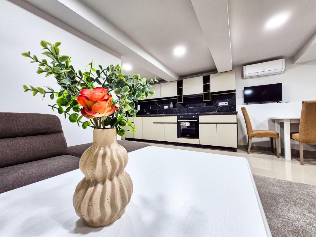 um vaso com uma flor numa mesa numa sala de estar em BunApart Ciorescu Cristal em Ciorescu