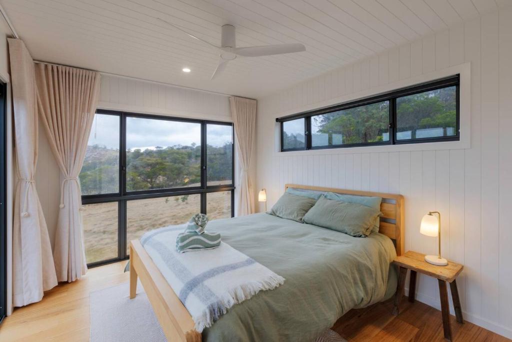 Un dormitorio con una cama y una ventana grande en Off-Grid Farm Stay with Scenic Views, en Tenterfield