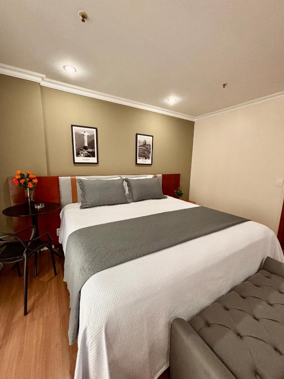 a bedroom with a large bed and a chair at Flat Barra Residence-3 pessoas-Fa1204-4 in Rio de Janeiro