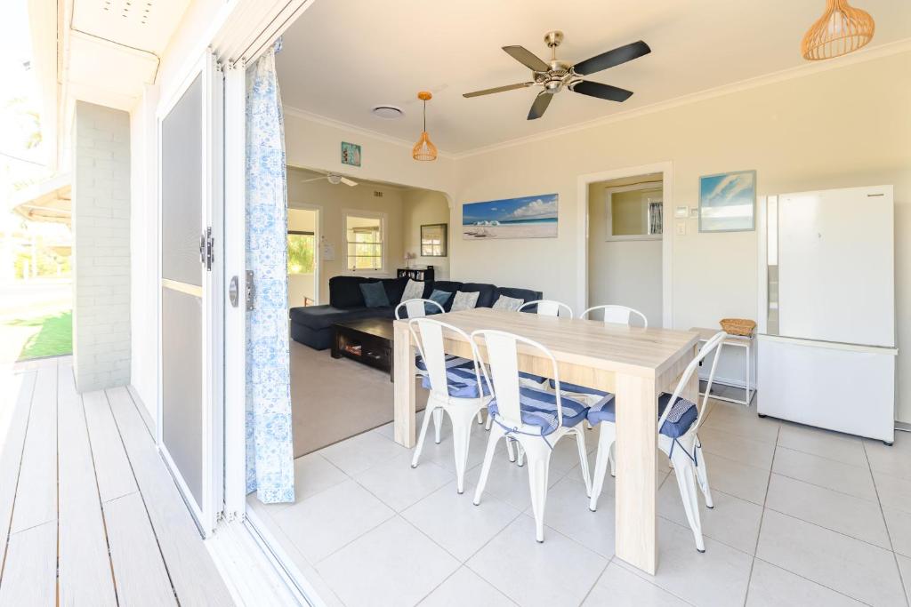 ein Esszimmer und ein Wohnzimmer mit Tisch und Stühlen in der Unterkunft Cypress Cottage 26 Cypress Street Evans Head in Evans Head