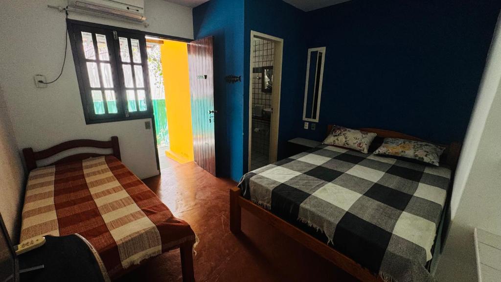 a bedroom with a bed and a window in it at Pousada 100 passos in Tamandaré