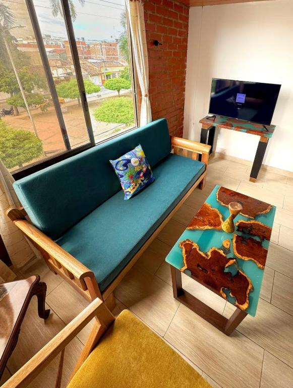 a living room with a blue couch and a table at Hermoso Apto Con Vista a la Basílica in Buga