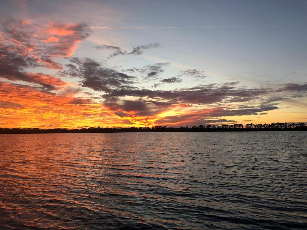 EastgateにあるLakeside Cabin for a Glamping Getaway near Tampa, Floridaの大きな水域に沈む夕日
