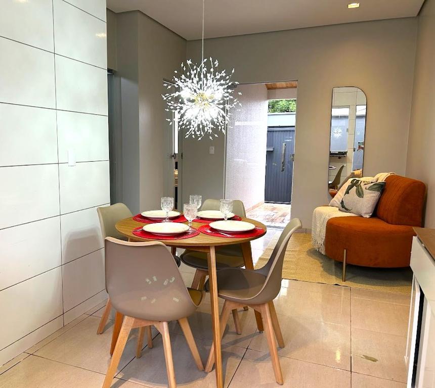 a dining room with a table and chairs and a couch at Casa 03 - Casa com 2 quartos, localizada próximo a rodoviária e aeroporto in Palmas