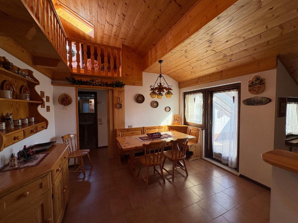 cocina y comedor con techo de madera en Mansarda Veronza, en Castello di Fiemme