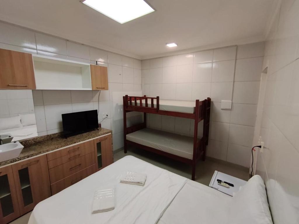 a small room with a bunk bed and a kitchen at Essenza Suites Natal in Natal