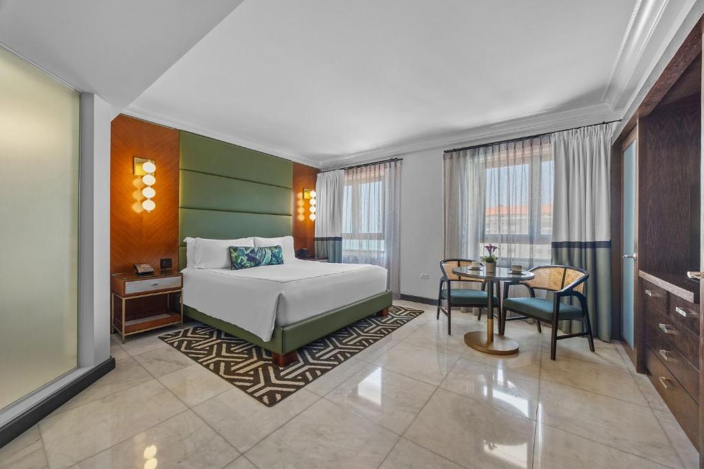 Un dormitorio con una cama y una mesa en una habitación. en Condado Vanderbilt Hotel, en San Juan