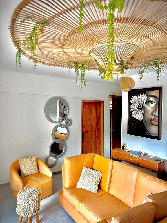 a living room with an orange couch and a chandelier at Zen escape-ocean view Papeete in Papeete