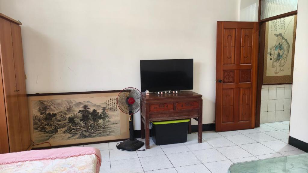 a room with a desk with a television and a fan at 豐陽客棧 in Fengyuan