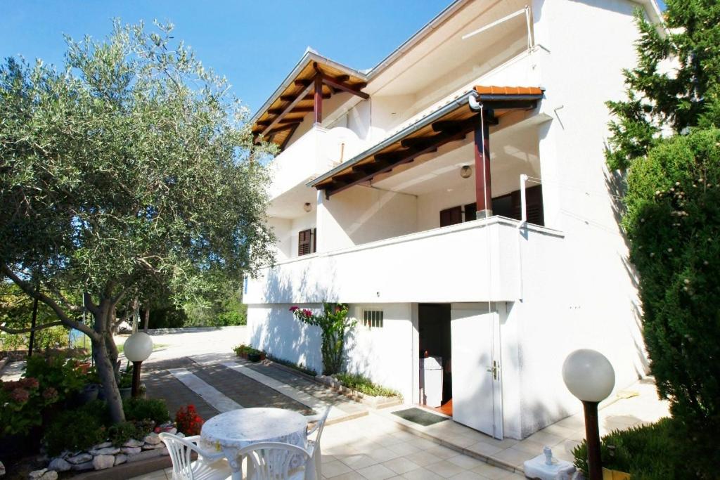 a white building with a table and chairs at Double Room Barbat 4862a in Barbat na Rabu