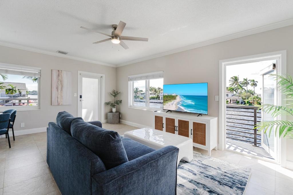 ein Wohnzimmer mit Sofa und Fernseher in der Unterkunft Waterfront Intercoastal, Walk to the Beach, Pool & Hot Tub, Watch the Boats in Boca Raton