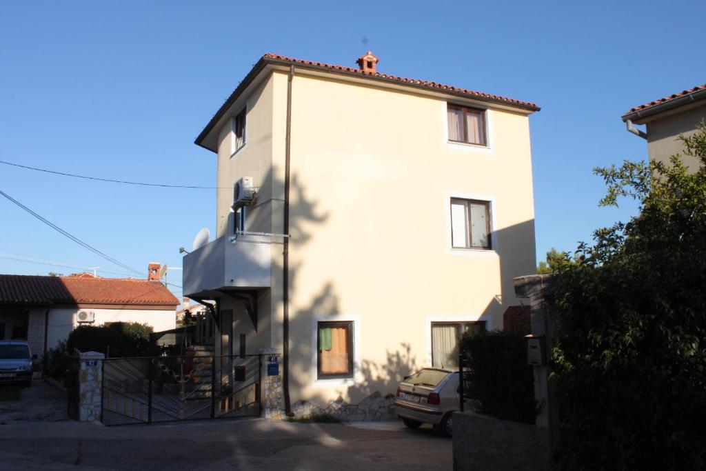 a white building with a car parked next to it at Apartment Pomer 7374a in Pomer