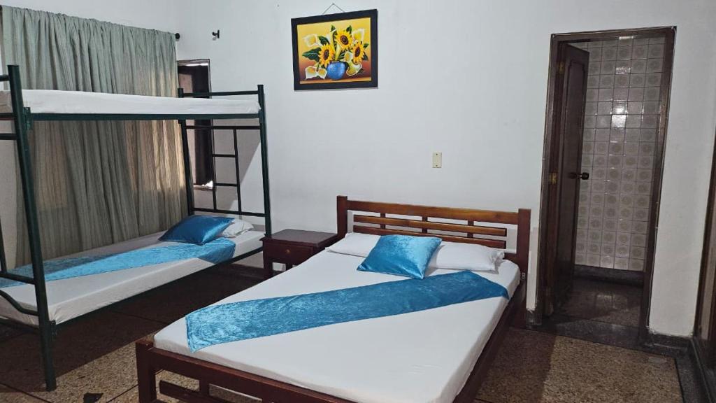 1 dormitorio con 2 literas y almohadas azules en Hotel Americano Plus, en Pereira