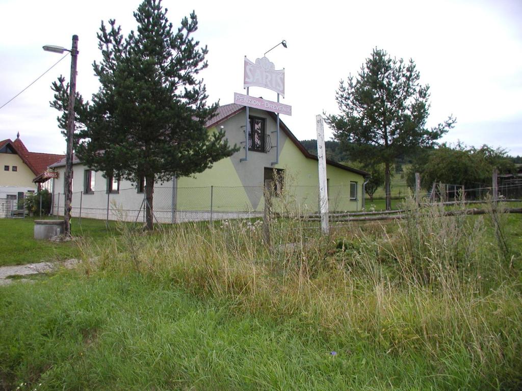 an old house with a cross on top of it at Penzion Dreveník in Spišské Podhradie