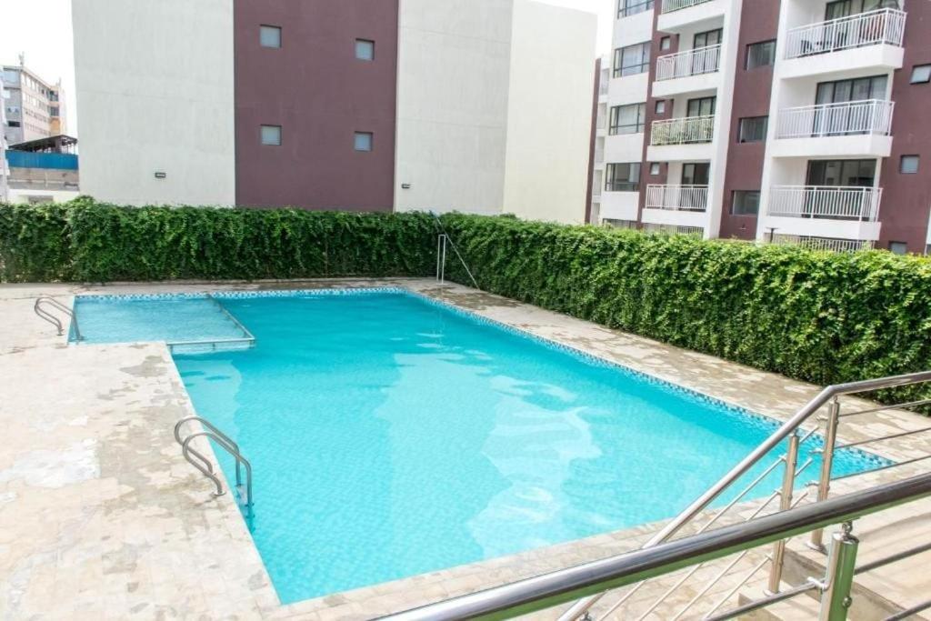 a large blue swimming pool in front of a building at Mathel Studio Home in Marimbeti