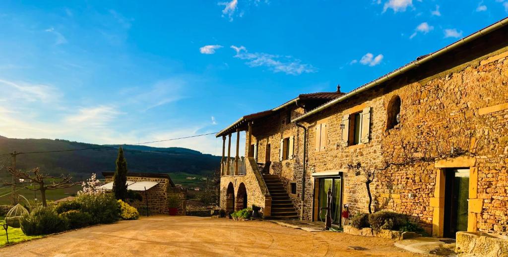 an old stone building with a road in front of it at Au Petit Bonheur chez Bambina in Leynes