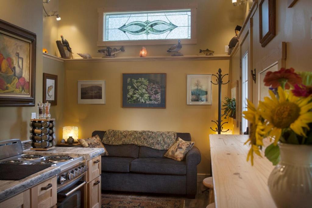 a living room with a couch and a kitchen at Rush River Cottage & Gardens in Ellsworth