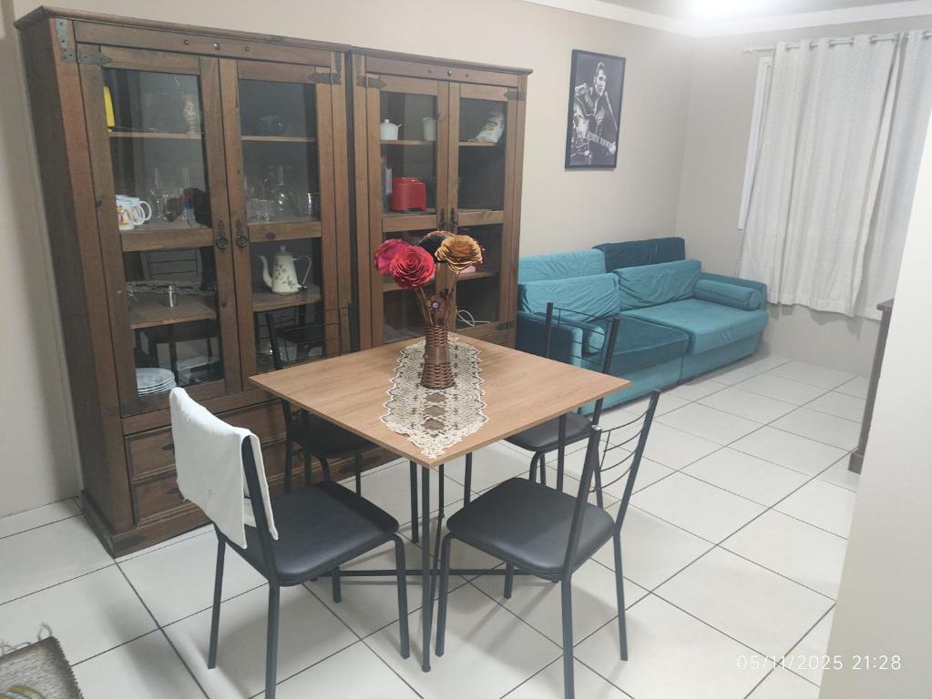 een woonkamer met een tafel, stoelen en een bank bij Apartamento Ótima Localização Turismo Faculdade in Bento Gonçalves