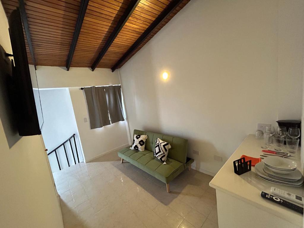 a living room with a green couch and a table at Vida Playa El Agua in La Mira