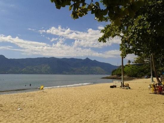 a beach with a view of the water and mountains at Casa Azul Jaraguá in São Sebastião