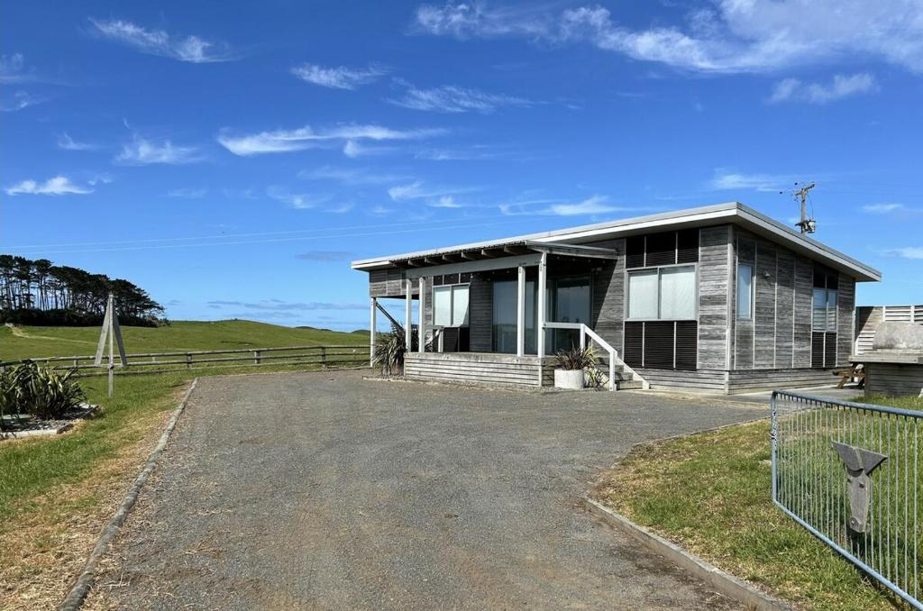 a house with a gravel driveway in front of it at The Shores Lakefront Retreat in Omamari