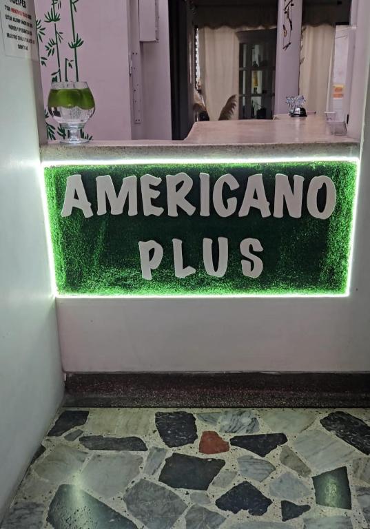 a sign for an americano plus on a store door at Hotel Americano Plus in Pereira