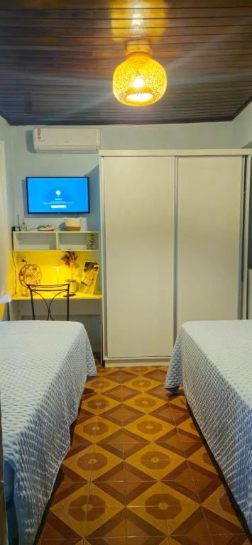 een kamer met twee bedden en een televisie bij Casa Janela Azul in Belém