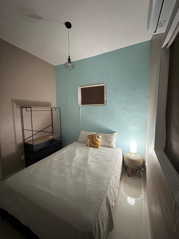 een slaapkamer met een wit bed en een tafel bij La Guacamaya Azul en Willemstad in Willemstad