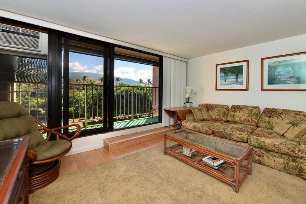 a living room with a couch and a large window at Kaleialoha 402 · KA 402 Spacious Studio Close to Ocean Heated Po in Kahana