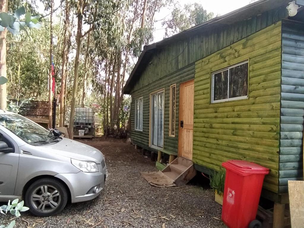 a car parked next to a green tiny house at Cabaña entre eucaliptos en Huaquén 3D 1B más patio in Guaquen