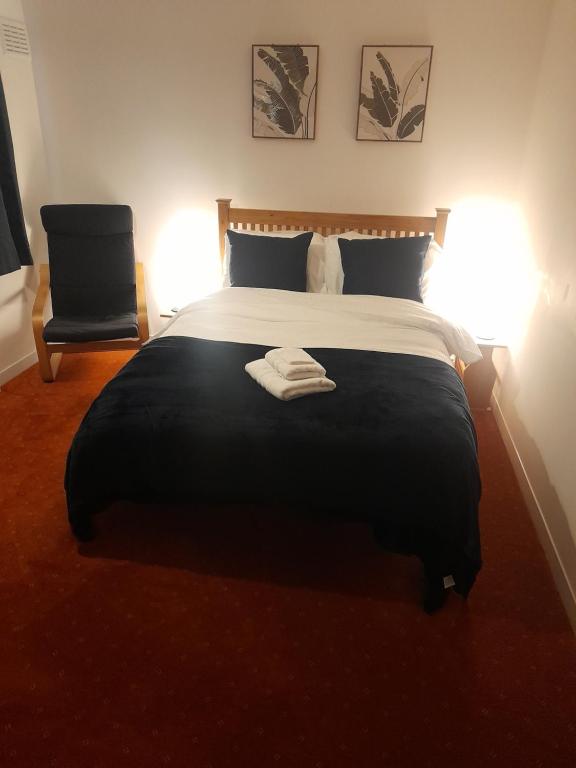 ディドコットにあるGreenviewのベッドルーム1室(大型ベッド1台、ランプ2つ、椅子付)