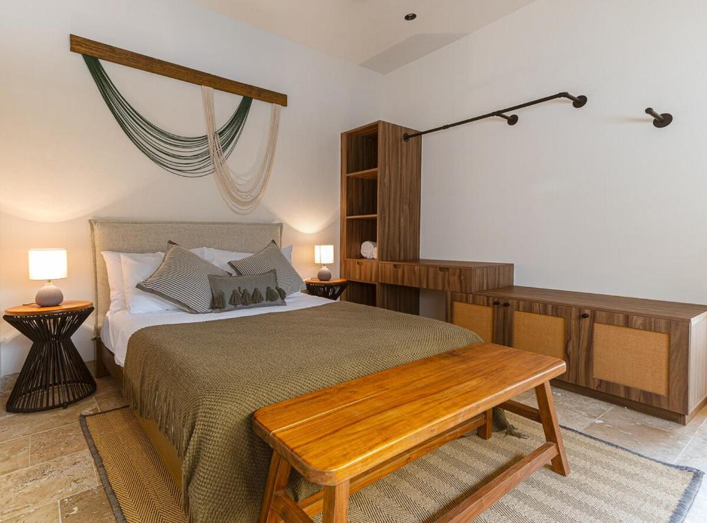 a bedroom with a bed and a wooden table at Casa KakMo in Izamal