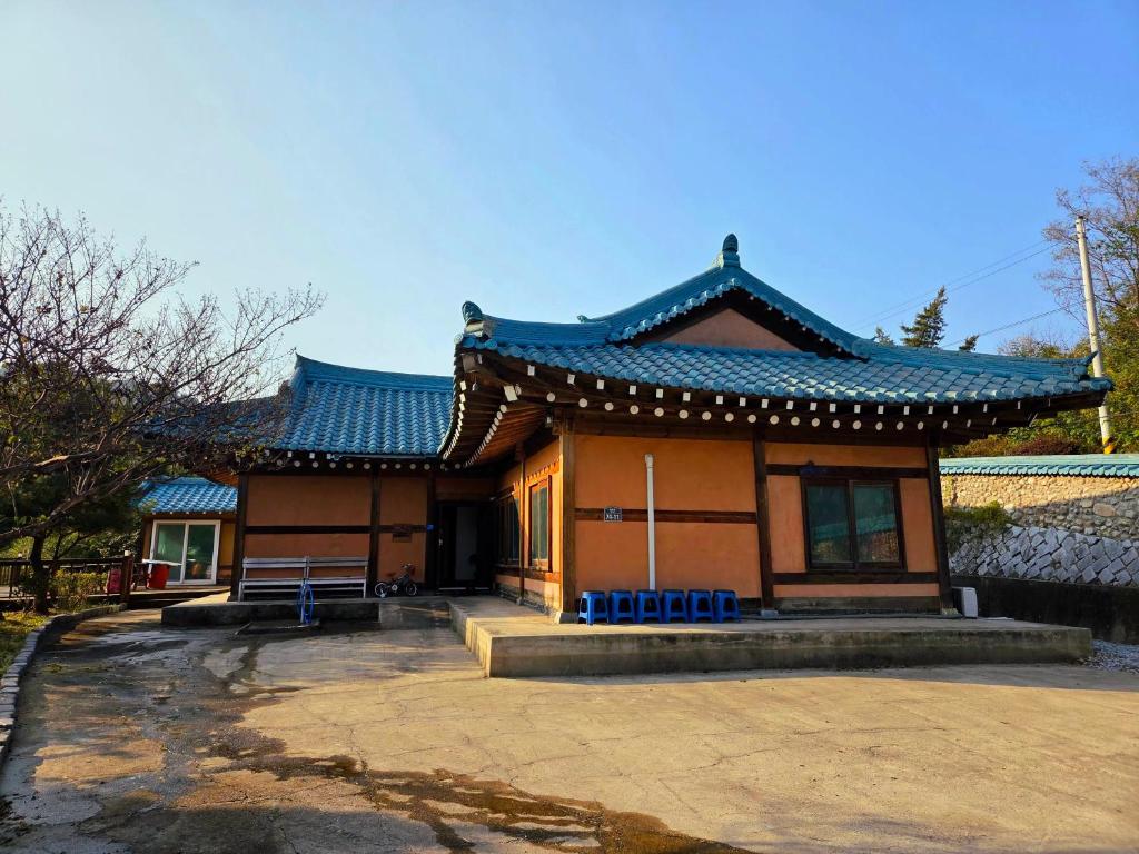 a building with a blue roof with a bench in front at Yangyang 88 Hanok Stay in Yangyang