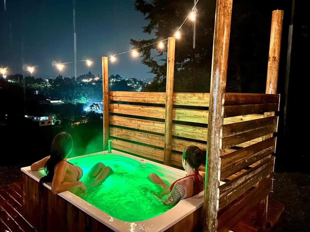 two children swimming in a hot tub at night at La Cabaña de Blue in Guarne