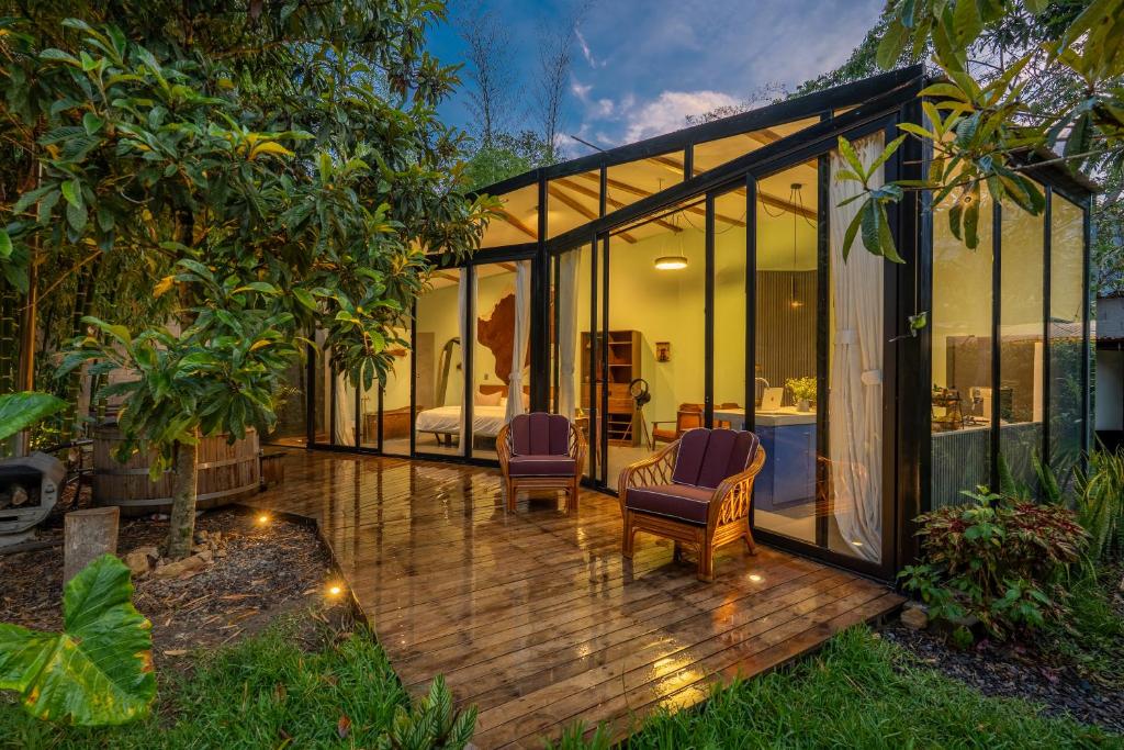 a glass house with two chairs and a bed at Romantic Mirror-Clad Tiny with Private Hot Tub in Pedro Ruiz Gallo