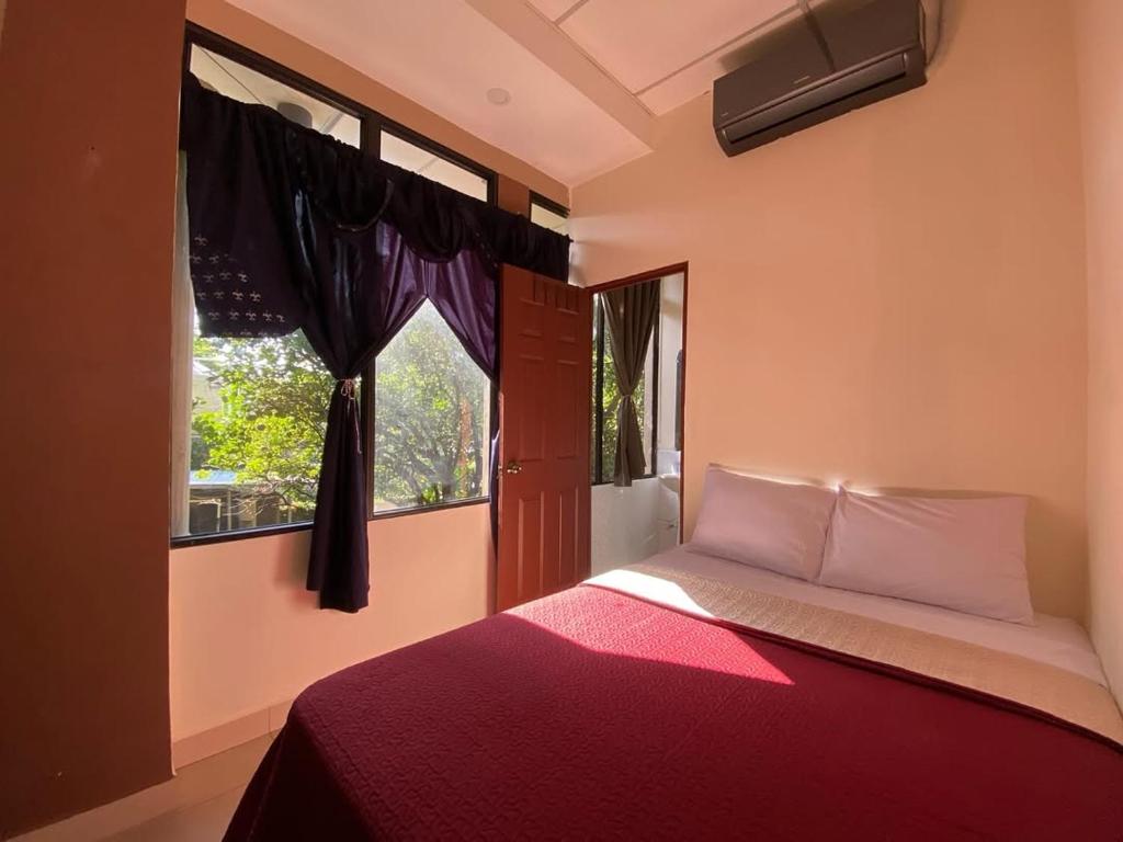 a bedroom with a red bed and a window at Hotal D Palacio Real in San Miguel