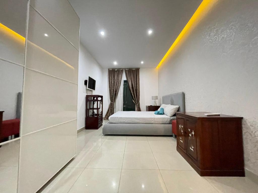 a bedroom with a bed and a dresser in a room at Modern Gzira 2BR Apartment Race2 in Il-Gżira