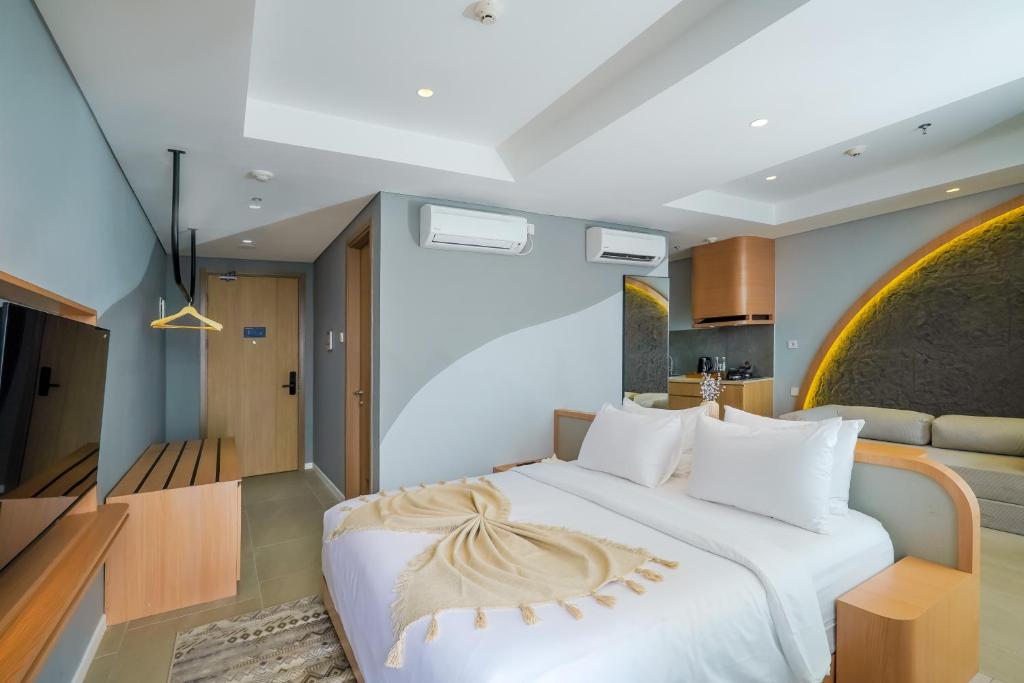 a bedroom with a large white bed and a couch at Morich Suites Antasari in Jakarta