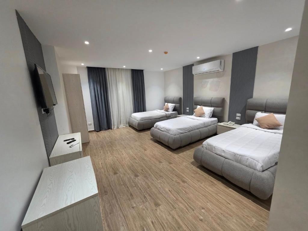 a hotel room with two beds and a flat screen tv at pyramids heaven hotel- فندق جنة الاهرامات in Giza