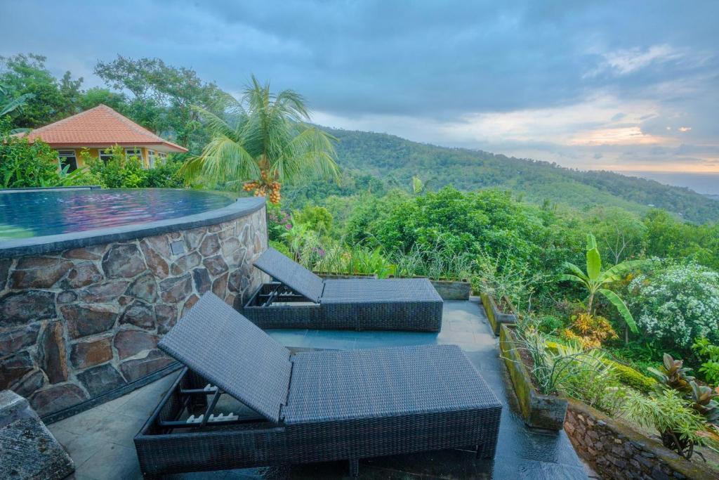 a patio with two chairs and a swimming pool at Maria Secret Villa in Lovina