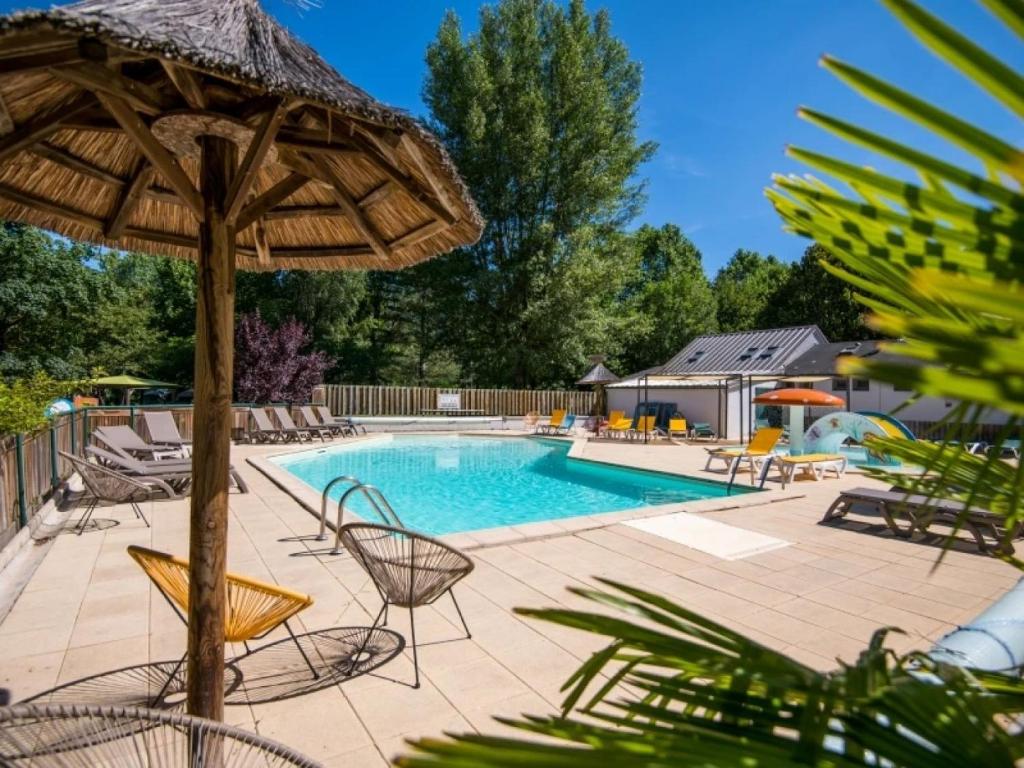 a swimming pool with chairs and an umbrella at Camping 3 étoiles - Piscine - eeed0b in Bédouès