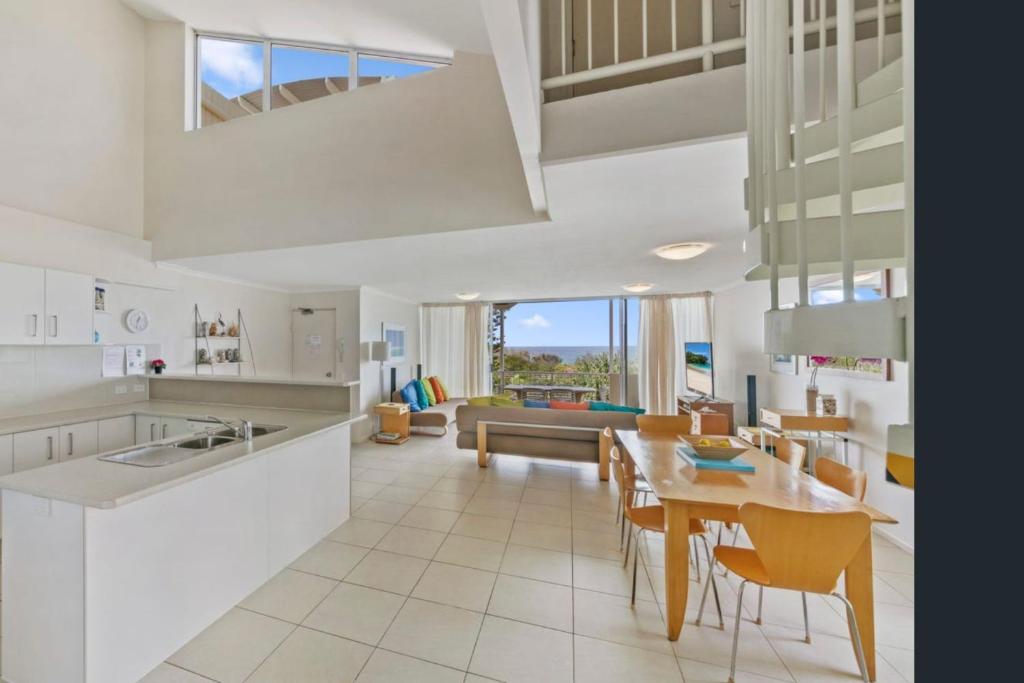 a kitchen and living room with a table and chairs at Unit 15 - 45 Lorikeet Drive, Peregian Beach in Peregian Beach