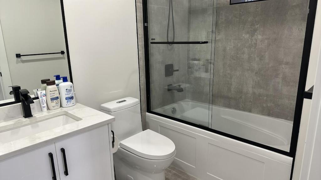 een badkamer met een douche, een toilet en een wastafel bij Metrotown area in Vancouver