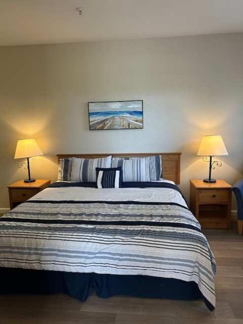 a bedroom with a large bed with two lamps at Lagoon View and Ocean Breeze in Oceano